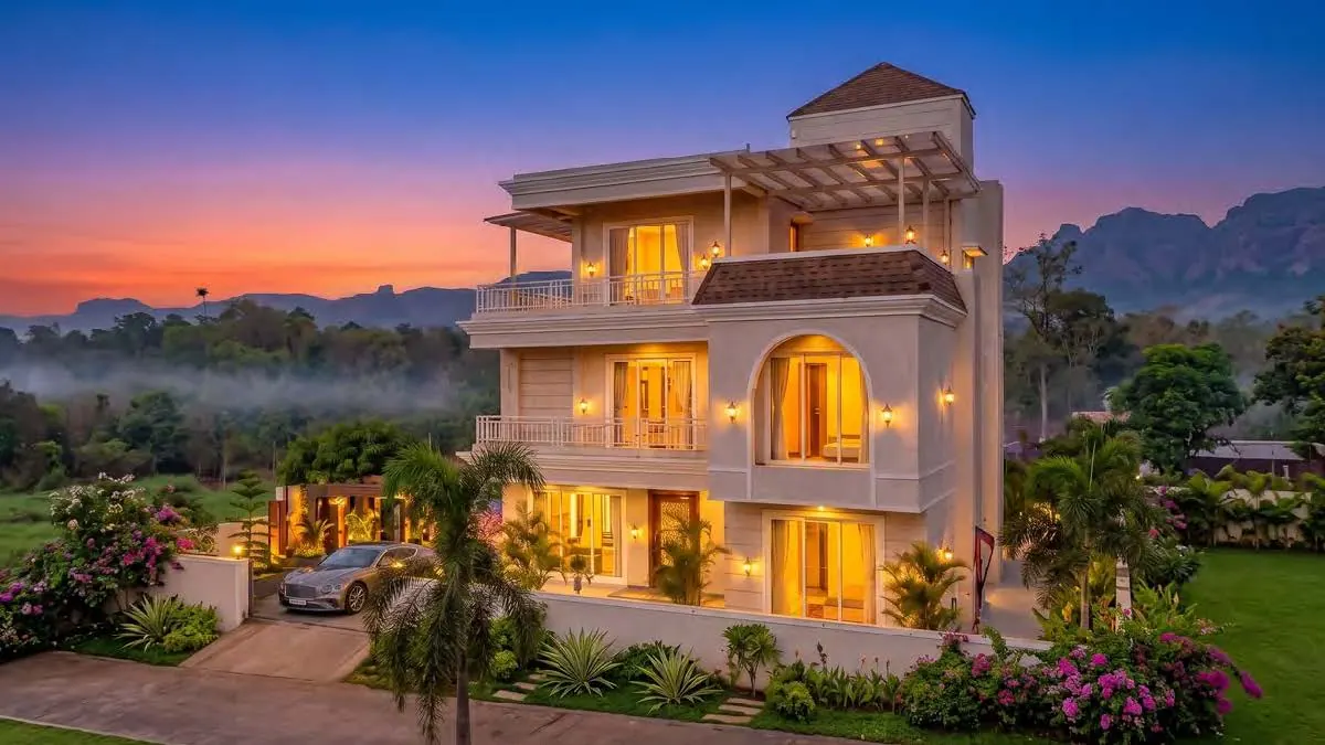 A villa at The Morning Star lit at dusk, with the hills behind